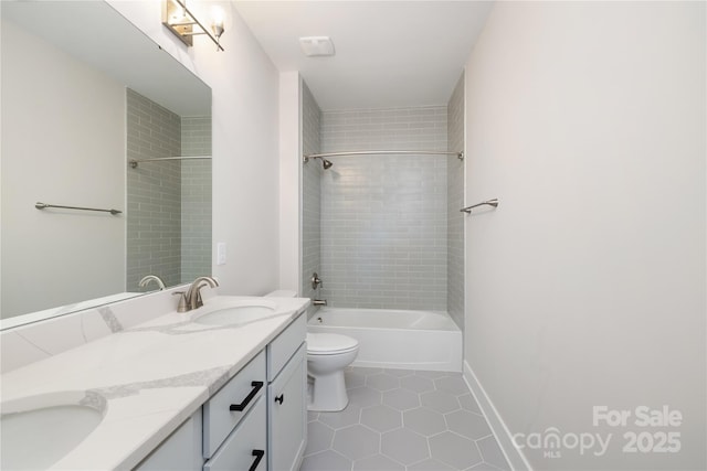 full bathroom with tile patterned floors, tiled shower / bath, vanity, and toilet