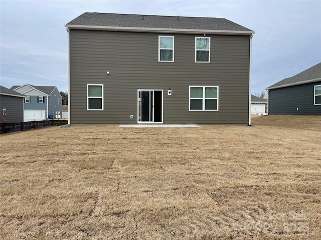 back of property with a yard and a patio