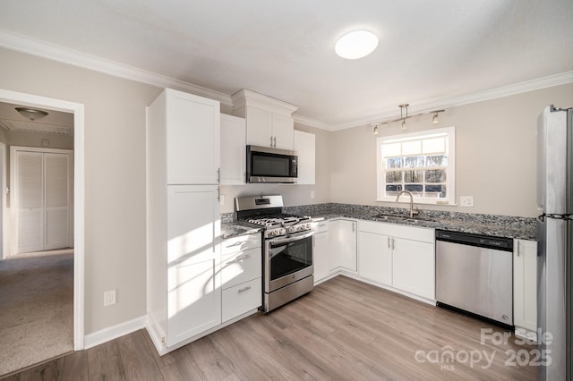 kitchen with sink, crown molding, white cabinetry, stainless steel appliances, and dark stone counters