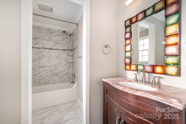 bathroom with tiled shower / bath, vanity, and crown molding