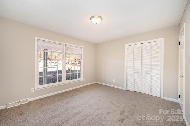 unfurnished bedroom featuring carpet and a closet