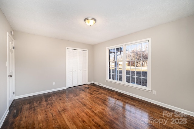 unfurnished room featuring dark hardwood / wood-style floors and a textured ceiling