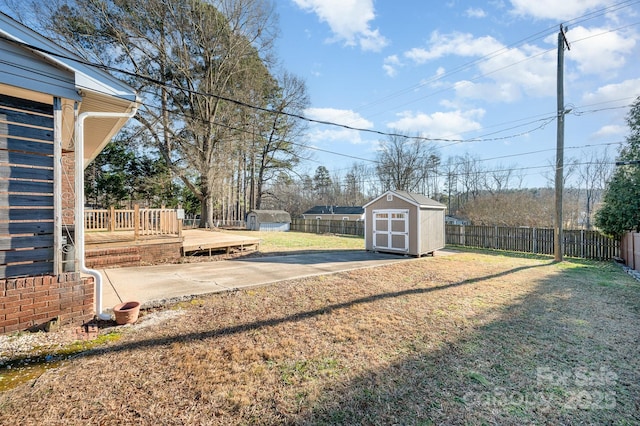 view of yard featuring a patio area, a deck, and a shed