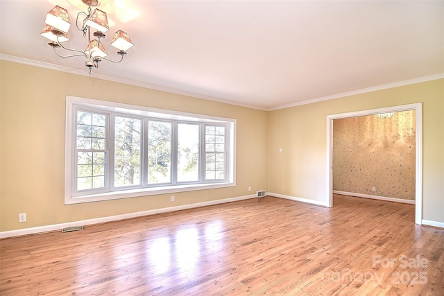 spare room with light hardwood / wood-style floors, crown molding, and an inviting chandelier