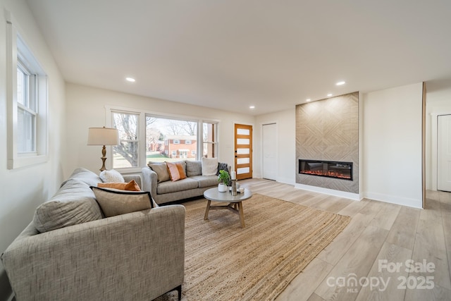 living room featuring a large fireplace and light wood-type flooring