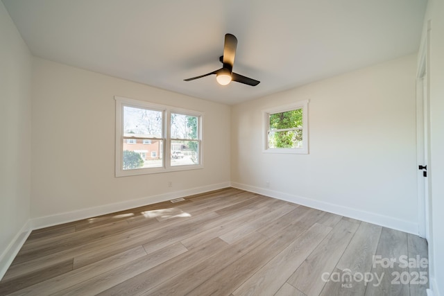 empty room with light hardwood / wood-style floors, ceiling fan, and a healthy amount of sunlight