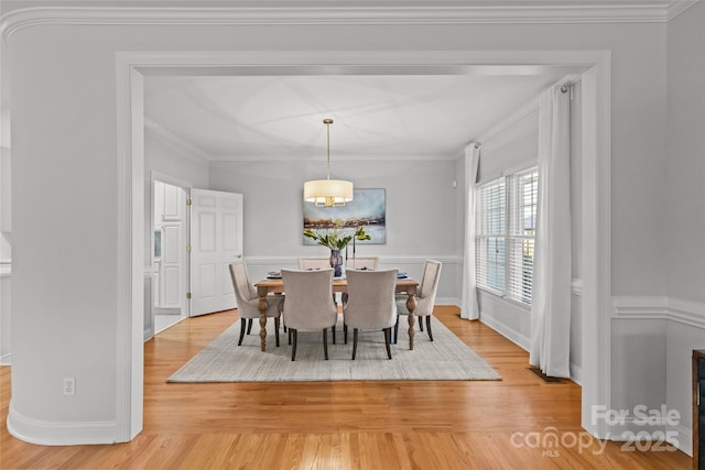 dining area featuring light hardwood / wood-style floors and crown molding