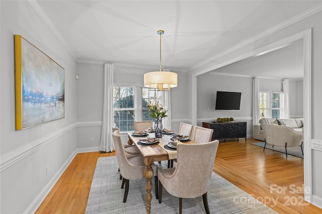 dining area featuring light hardwood / wood-style floors and ornamental molding