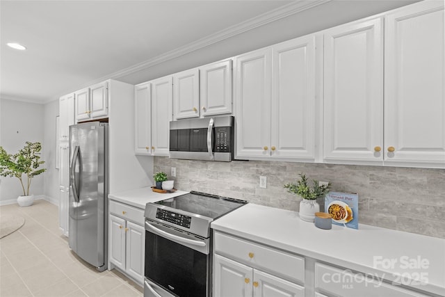 kitchen featuring light tile patterned floors, stainless steel appliances, crown molding, and white cabinetry