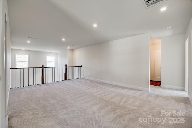 spare room with light carpet, baseboards, visible vents, and recessed lighting