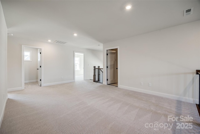 unfurnished room with recessed lighting, visible vents, baseboards, and light colored carpet