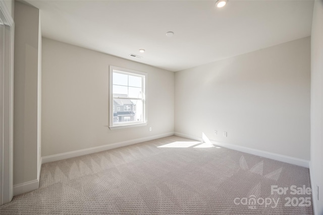 carpeted empty room featuring recessed lighting and baseboards