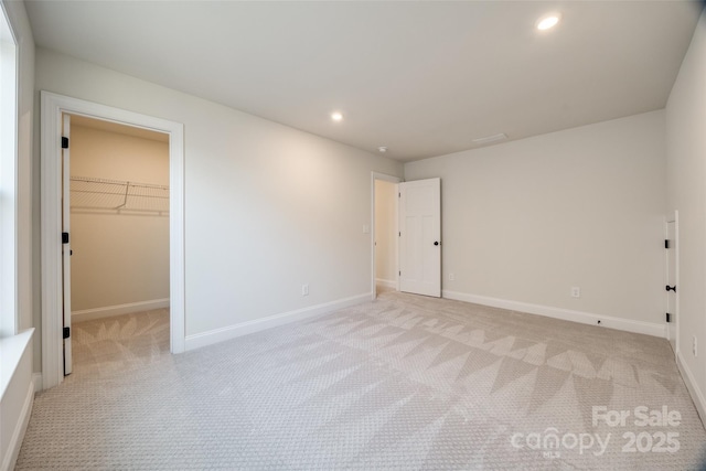 spare room featuring recessed lighting, light colored carpet, and baseboards