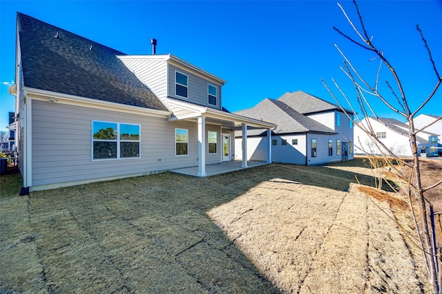 back of property featuring a shingled roof and a patio area