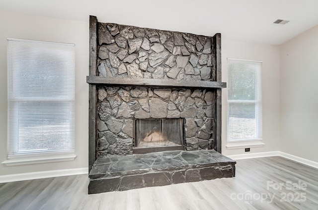 details featuring a stone fireplace and hardwood / wood-style flooring