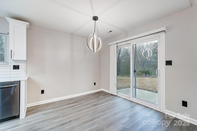 unfurnished dining area with light wood-type flooring