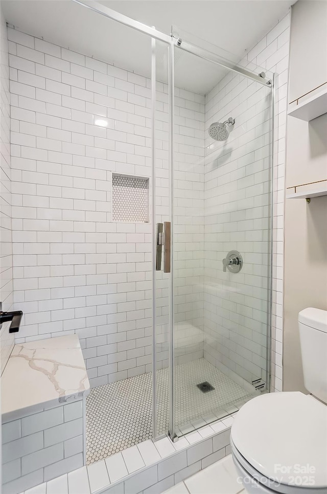 bathroom with a shower with door and toilet