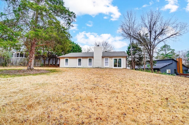 rear view of property with a lawn