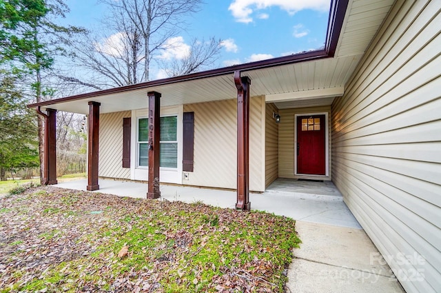 view of exterior entry featuring covered porch