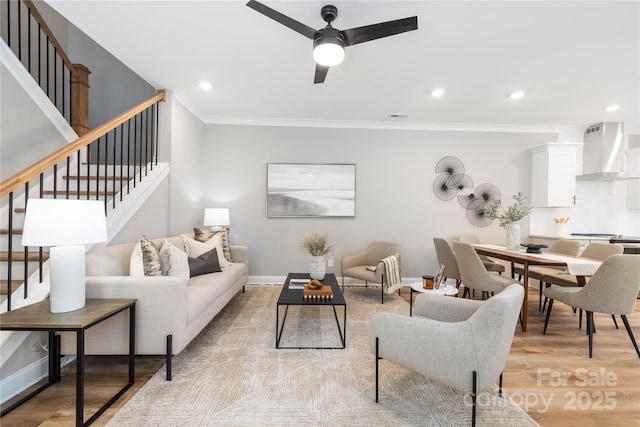 living room featuring ceiling fan, light hardwood / wood-style floors, and ornamental molding