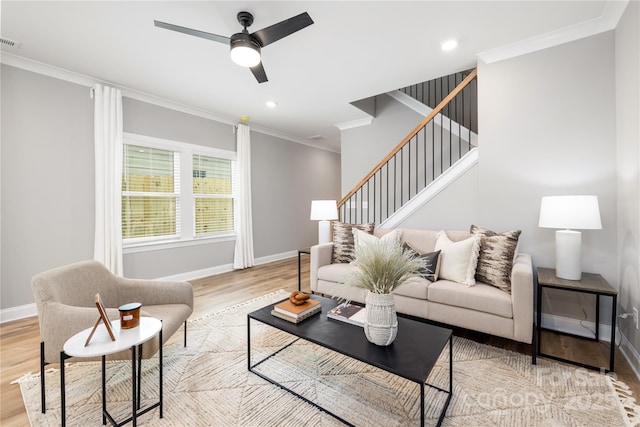 living room featuring light hardwood / wood-style flooring, ceiling fan, and ornamental molding