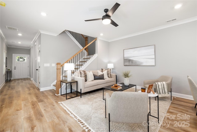 living room with light wood-type flooring, ceiling fan, and crown molding