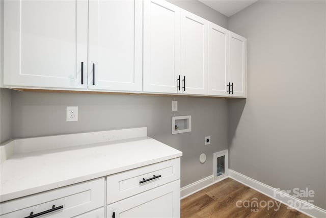 laundry area with electric dryer hookup, cabinets, dark wood-type flooring, hookup for a gas dryer, and washer hookup