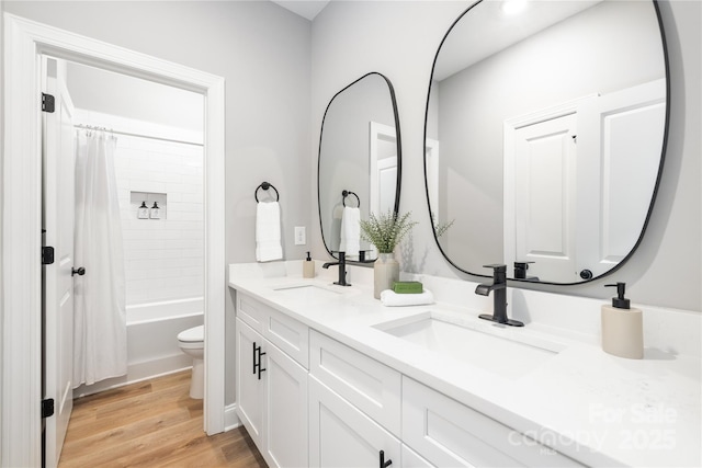 full bathroom featuring hardwood / wood-style floors, vanity, shower / bath combination with curtain, and toilet