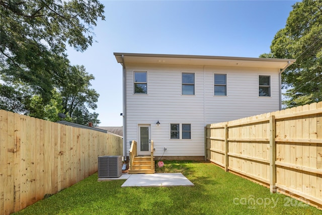 back of property featuring central air condition unit and a yard