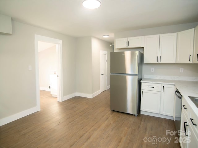 kitchen featuring white cabinets, appliances with stainless steel finishes, and light hardwood / wood-style floors