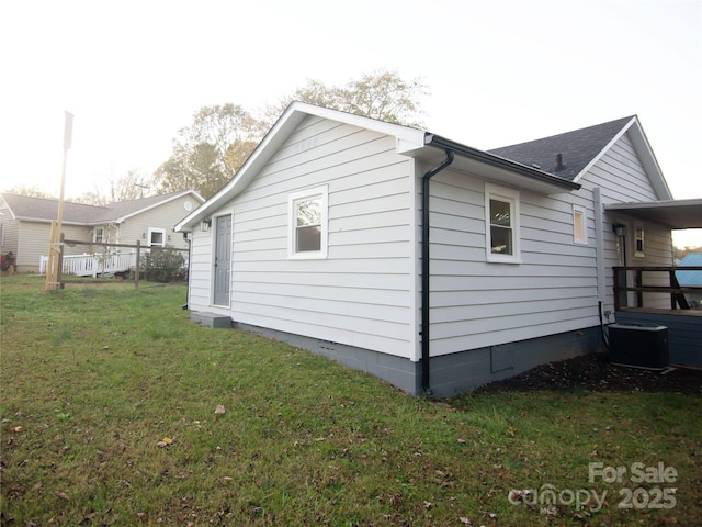 view of side of home featuring a yard and cooling unit