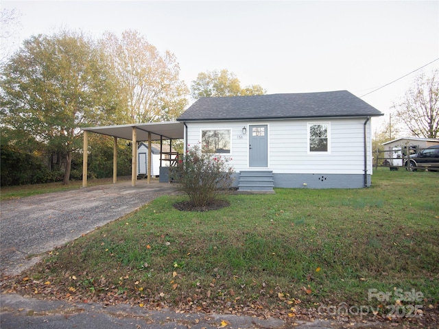 view of front facade with a front lawn and a carport