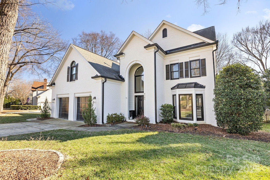 view of front of house with a garage and a front lawn