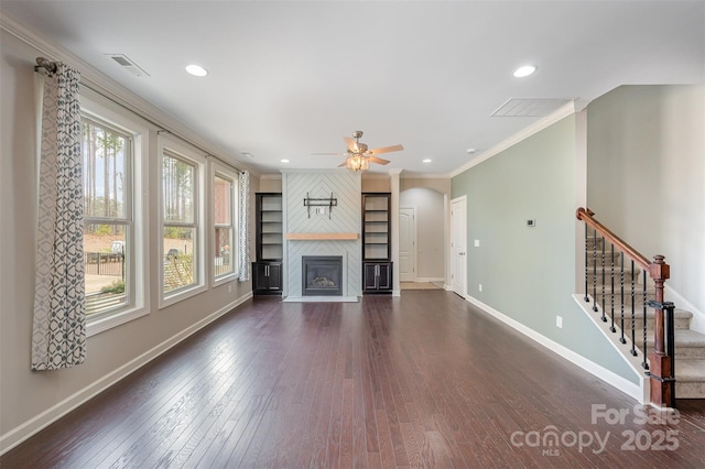 unfurnished living room with a large fireplace, ceiling fan, ornamental molding, and dark hardwood / wood-style flooring