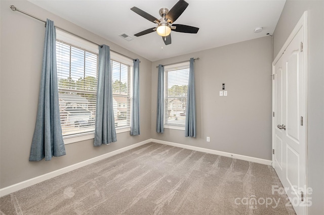 carpeted empty room featuring ceiling fan