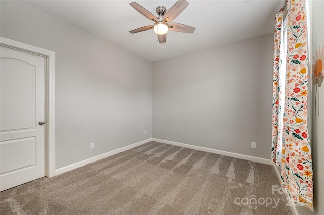 spare room with ceiling fan and carpet