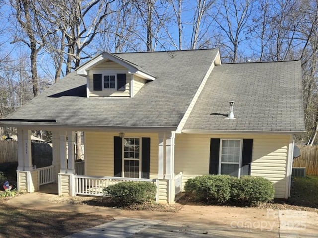 new england style home featuring a porch and cooling unit