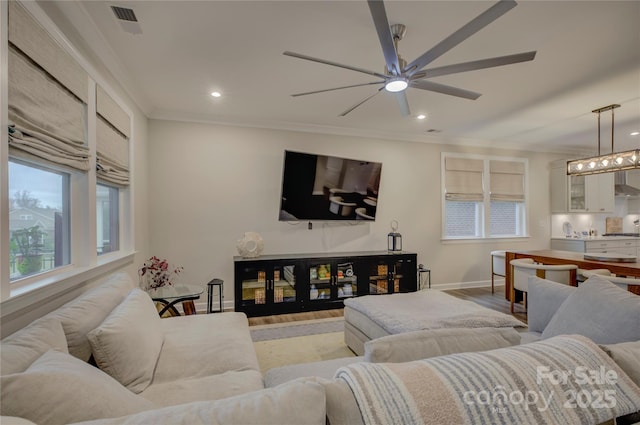 living room featuring light hardwood / wood-style floors, ceiling fan, and ornamental molding