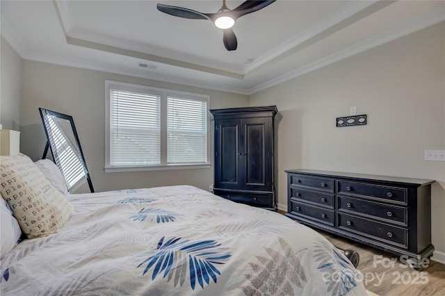 bedroom with a tray ceiling, ceiling fan, and ornamental molding