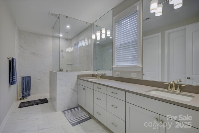 bathroom featuring a tile shower and vanity