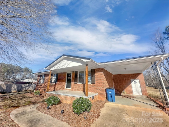 ranch-style home featuring a carport and covered porch