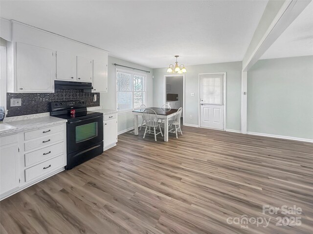 kitchen featuring white cabinets, backsplash, and black electric range oven