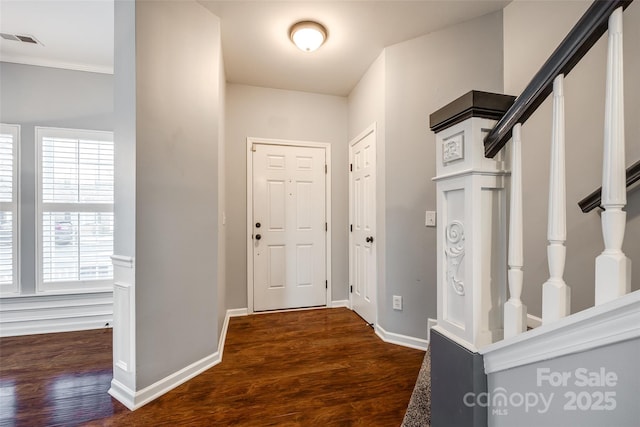 foyer entrance featuring dark hardwood / wood-style floors, plenty of natural light, and ornamental molding