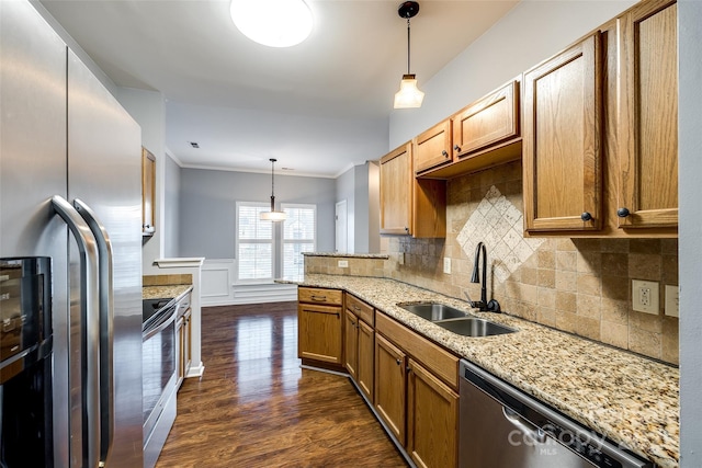 kitchen with light stone countertops, sink, hanging light fixtures, decorative backsplash, and appliances with stainless steel finishes