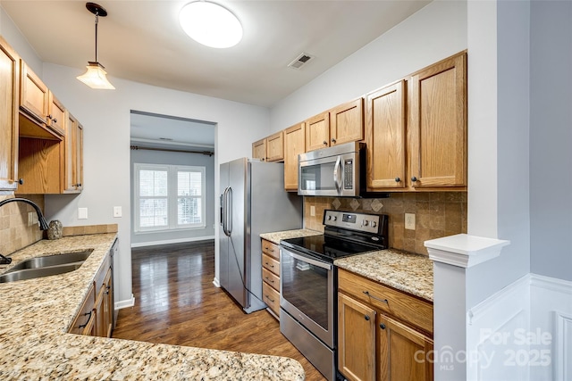 kitchen with tasteful backsplash, sink, hanging light fixtures, and appliances with stainless steel finishes