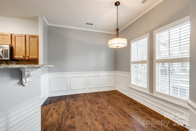 unfurnished dining area featuring dark hardwood / wood-style flooring and crown molding