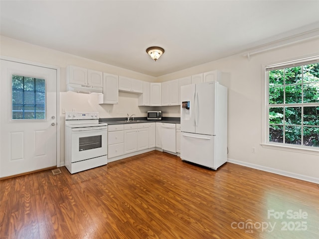 kitchen with white cabinets, white appliances, dark wood-type flooring, and sink