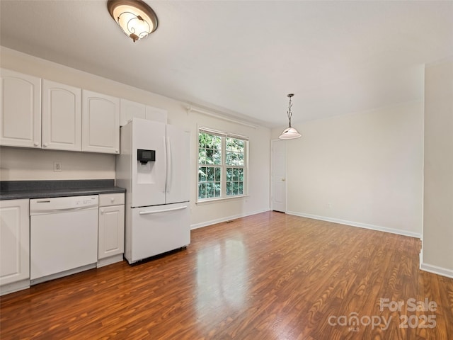 kitchen featuring white cabinets, white appliances, decorative light fixtures, and dark wood-type flooring