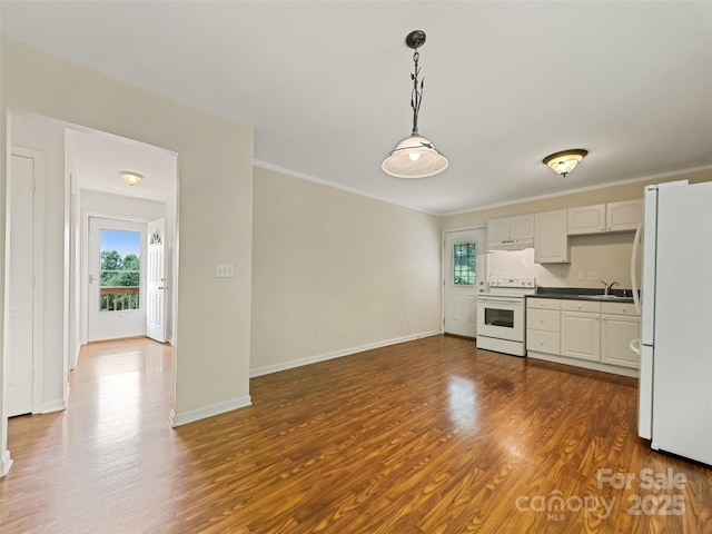 kitchen with sink, dark wood-type flooring, hanging light fixtures, white appliances, and white cabinets