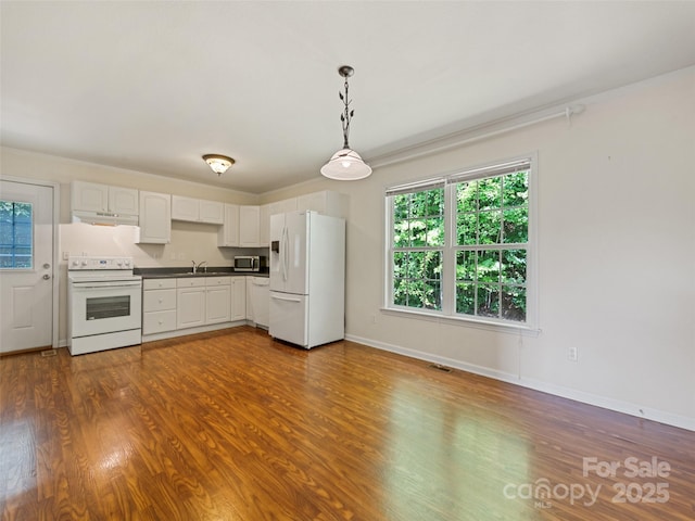 kitchen featuring pendant lighting, white appliances, sink, dark hardwood / wood-style floors, and white cabinetry